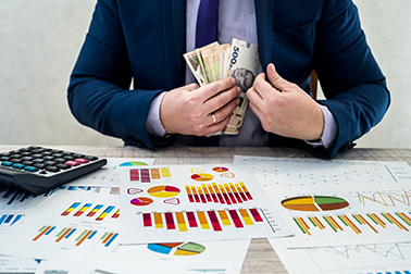 young businessman in office counts money as profit after a succe